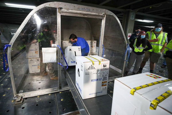 Workers load boxes labeled 